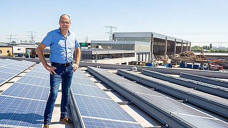 Directeur Jan Vrij op het nieuwe gebouw vol zonnepanelen